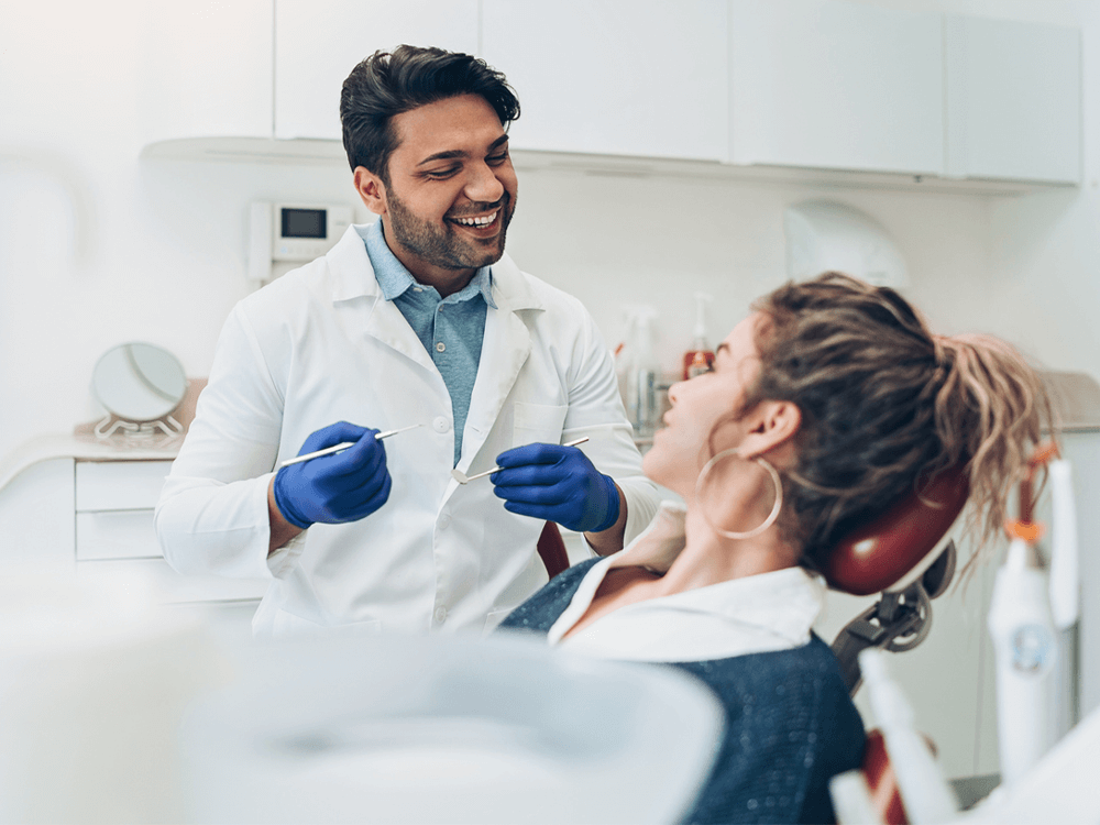 a dentist smiling during a patient exam