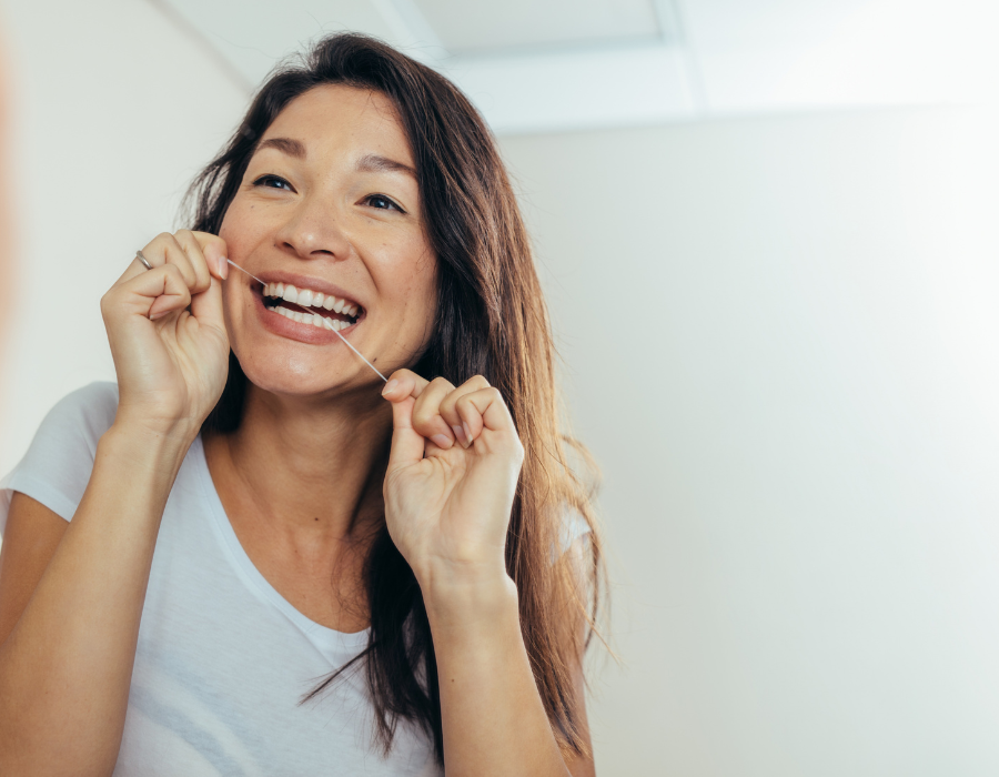 a woman flossing her teeth