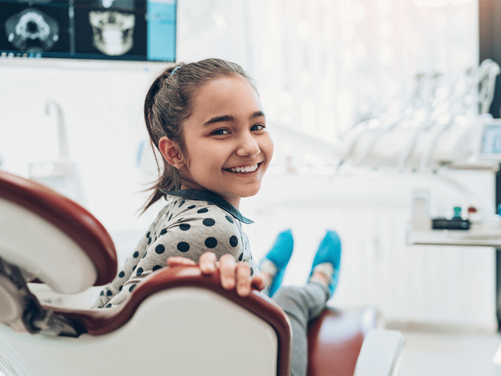 a young girl smiling in a dental exam room